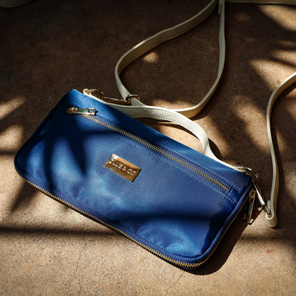 Blue handbag with a visible brand logo on a textured surface